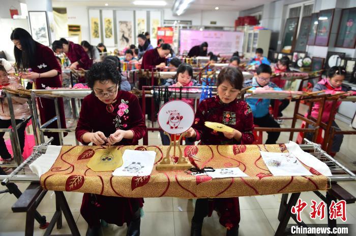 江西省級(jí)非遺豫章繡傳承人手把手指導(dǎo)小學(xué)生繡制2022年北京冬奧會(huì)吉祥物“冰墩墩”形象?！∮髟屏?攝