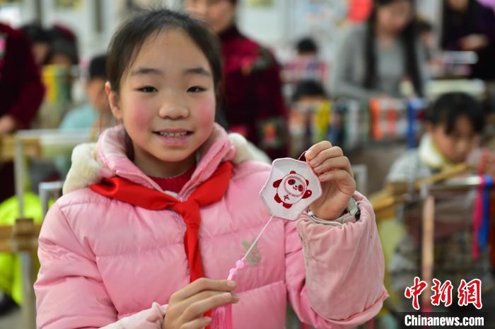 圖為一名小學(xué)生繡制的2022年北京冬奧會(huì)吉祥物“冰墩墩”形象。　喻云亮 攝