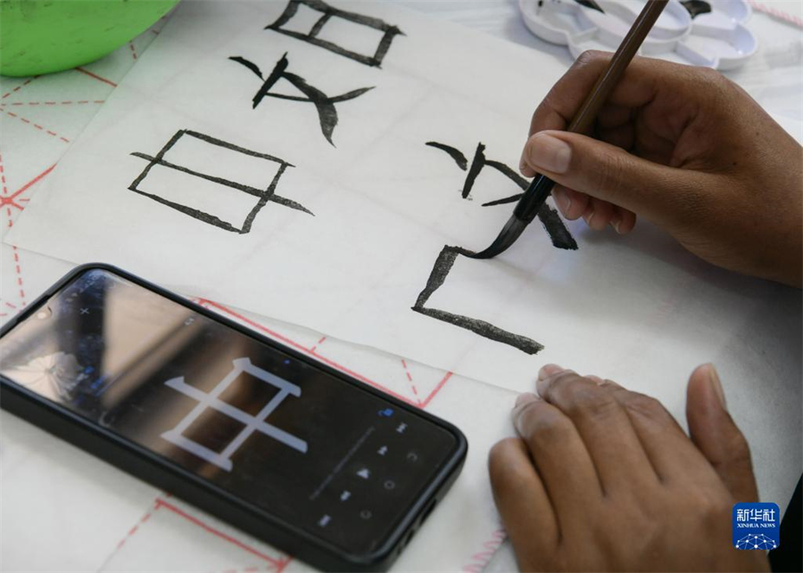 4月18日，肯尼亞學(xué)生在內(nèi)羅畢大學(xué)孔子學(xué)院舉辦的活動(dòng)上寫毛筆字?？夏醽唭?nèi)羅畢大學(xué)孔子學(xué)院18日舉辦“中文，增進(jìn)文明對(duì)話”主題活動(dòng)，慶祝即將到來的第14個(gè)聯(lián)合國(guó)中文日?？夏醽唽W(xué)生參與互動(dòng)，進(jìn)行書法、剪紙、唱中文歌等活動(dòng)。新華社記者 韓旭 攝