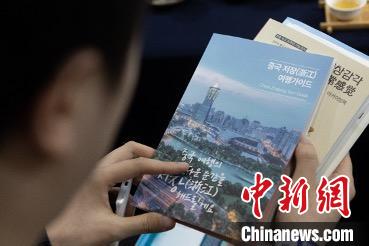 參展觀眾閱讀浙江文旅手冊?！《≌裾?攝