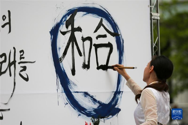 5月30日，在韓國首爾舉辦的“中日韓合作之日”慶?；顒又?，表演者進(jìn)行中日韓精神——2023年度漢字“和合”書法表演。新華社記者 王益亮 攝