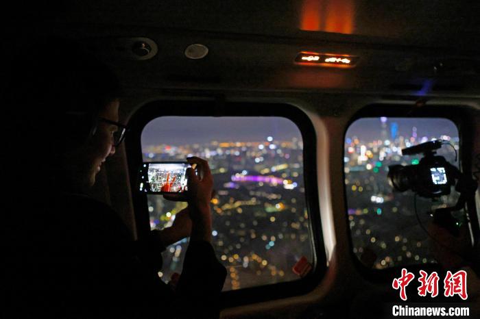 6月3日晚，游客乘坐上海新空直升機有限公司直升機開啟鳥瞰黃浦江空中圓夢之旅，并用手機拍攝城市夜景?！∫罅⑶?攝
