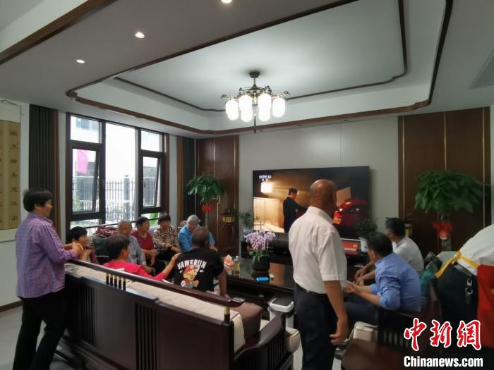 親友們集中在費(fèi)俊龍家中觀看返程的視頻?！＄娚?攝