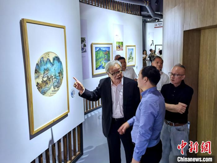 海峽兩岸藝術(shù)家畫展上，藝術(shù)家進(jìn)行藝術(shù)交流?！「毒窜?攝