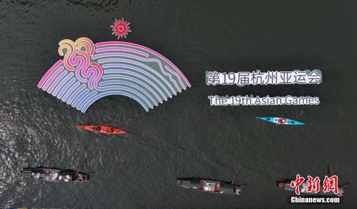 資料圖為烏篷船和皮劃艇從杭州亞運(yùn)會(huì)標(biāo)識(shí)前劃過(guò)。王剛 攝