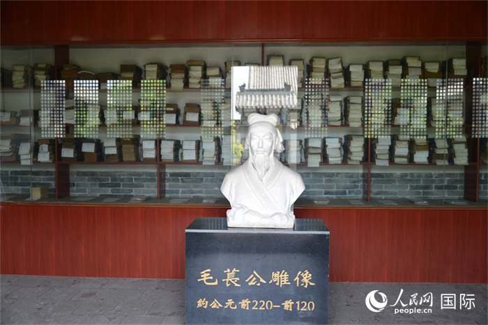 河間詩(shī)經(jīng)齋毛萇雕像。雕像后書(shū)櫥中陳列的是歷代各版本《詩(shī)經(jīng)》及譯本。 人民網(wǎng) 趙昭攝