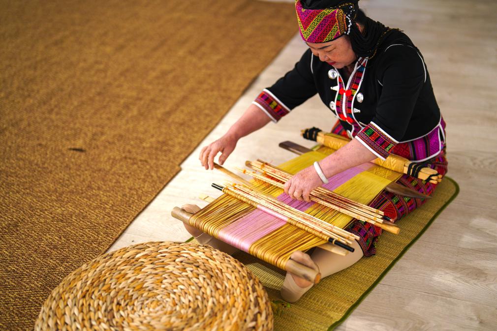 4月17日，黎族傳統(tǒng)紡染織繡技藝國家級代表性傳承人劉香蘭在2023年意大利米蘭設計周上展示黎錦織造技藝。新華社發(fā)