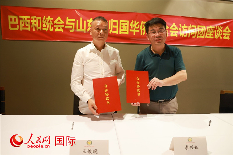 中國僑聯(lián)副主席、山東省僑聯(lián)主席李興鈺（右）與巴西和統(tǒng)會會長王俊曉簽署合作協(xié)議書。人民網(wǎng)記者 陳海琪攝
