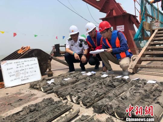 圖為勘察設(shè)計(jì)人員與海事局工作人員查看巖芯情況?！∥赫?攝