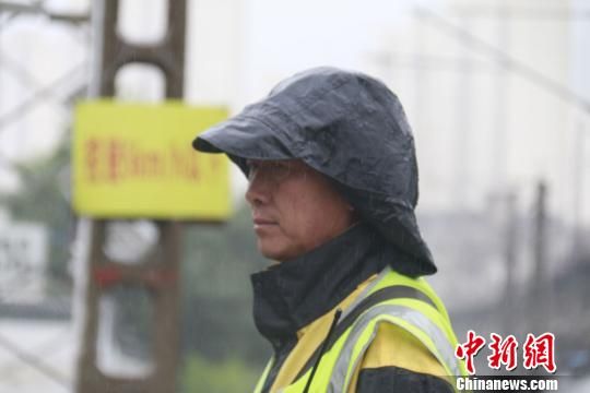 蘭州西工務(wù)段蘭州線路車間防護(hù)員雨中巡查。　王光輝 攝