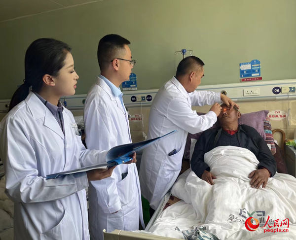 董光明（左三）帶領醫(yī)生對患者進行術前檢查。人民網記者 杜燕飛攝