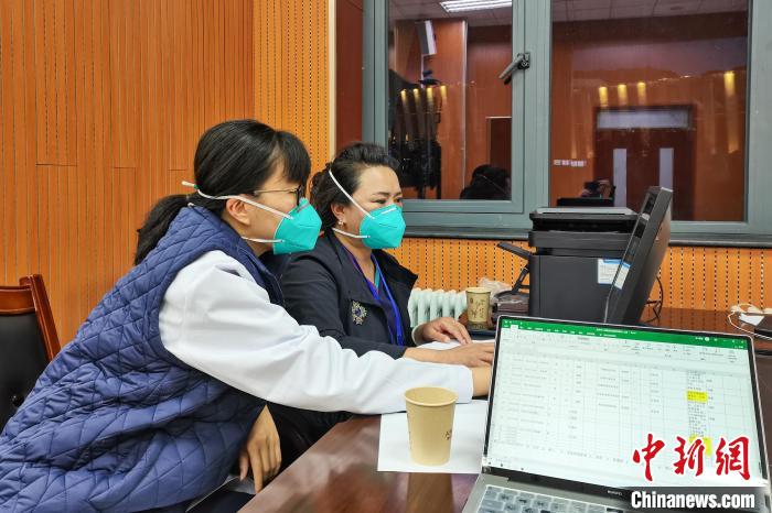 8月9日，楊蘇喬(左)在拉薩方艙醫(yī)院指揮部讀取艙內患者胸部CT。　受訪者供圖