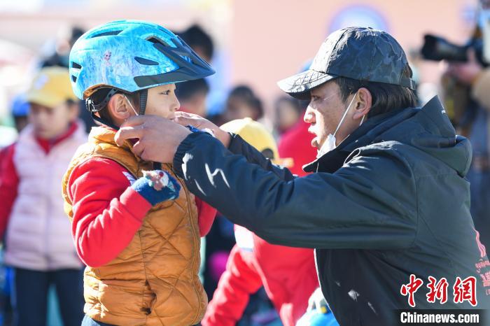 圖為拉薩市實驗幼兒園孩子在教練的幫助下穿戴頭盔?！『闻罾?攝