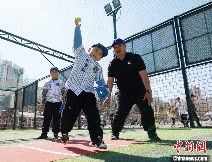 圖為來自臺(tái)灣的棒球教練劉興鴻(右)指導(dǎo)小棒球手?jǐn)S球技術(shù)?！●R銘言 攝