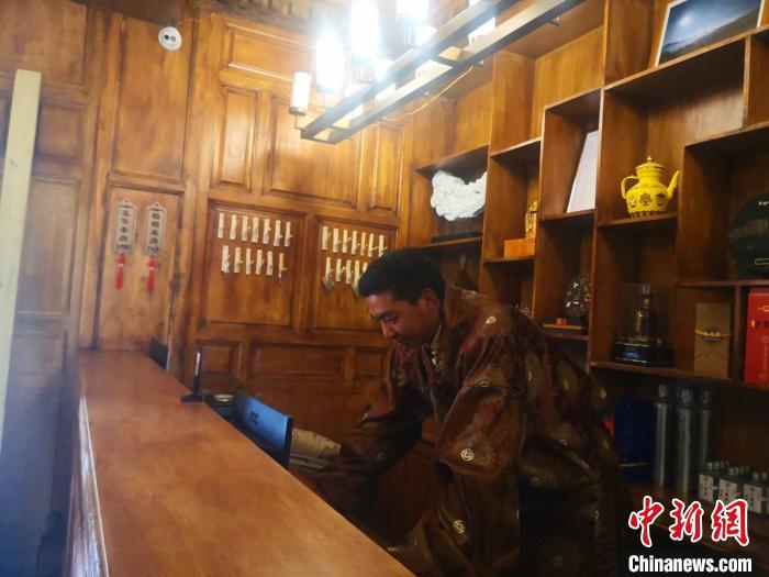 圖為桑杰才讓用電腦處理財(cái)務(wù)?！∈缝o靜 攝
