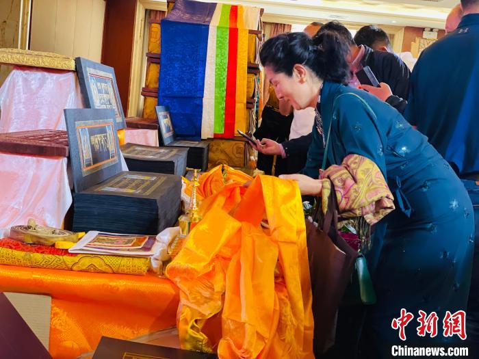圖為現(xiàn)場藏族民眾向黃金書寫的大藏經(jīng)《甘珠爾》敬獻哈達?！O睿 攝