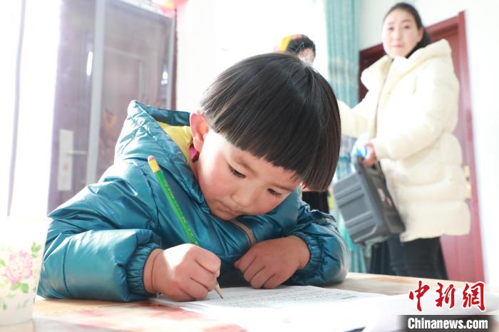 孩子們?cè)诩议T口上學(xué)，是楊周馬草搬入蘭州新家最為開心的事情。小女兒楊洋正在學(xué)習(xí)寫數(shù)字?！∥航ㄜ?攝