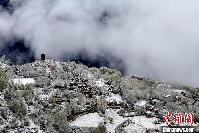 雪后的藏寨和碉樓構(gòu)成美麗的雪景?！〗党鯘衫?攝