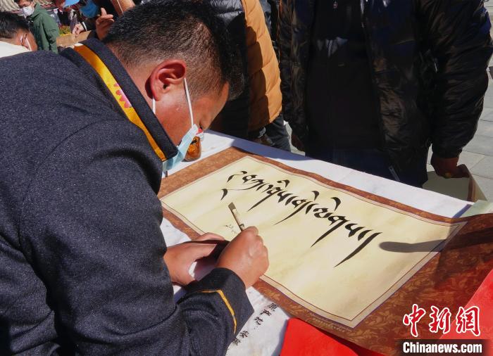 圖為書法家展示藏文書法?！∪轿木?攝