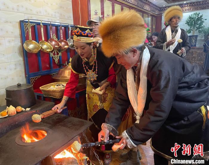 圖為人們在火上烤節(jié)日美食“結(jié)達(dá)”。　冉文娟 攝
