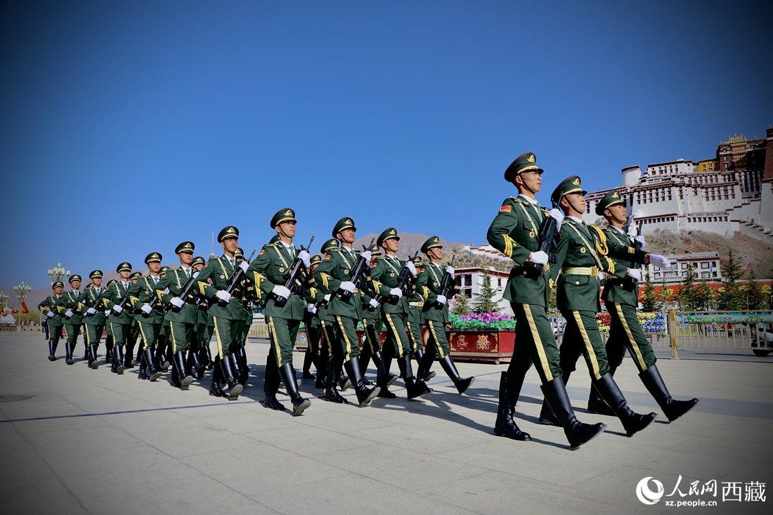 國旗護衛(wèi)隊隊員緊握鋼槍，踏著威武雄壯的步伐，走向國旗臺。人民網(wǎng) 次仁羅布攝