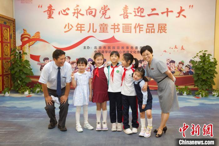 圖為與會(huì)嘉賓與入選畫(huà)作的“小作者”們?cè)谡褂[上合影?！≈袊?guó)藏學(xué)研究中心供圖