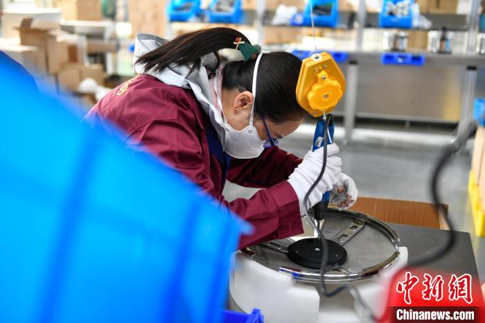 圖為工人正在組裝炊具?！∝暩聛硭?攝