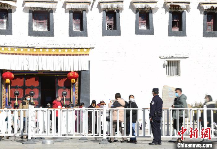圖為1月23日，布達(dá)拉宮廣場(chǎng)派出所民警正在引導(dǎo)游客?！∝暩聛硭?攝