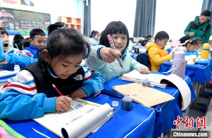 3月14日，西藏拉薩市第一小學一年級六班學生白瑪朗珍(圖左)在藏語文課上書寫藏文?！±盍?攝