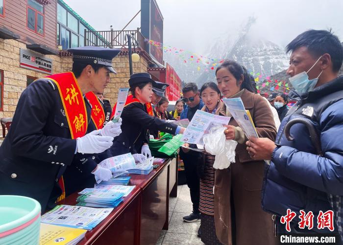圖為山南玉麥邊境派出所民警為轄區(qū)群眾發(fā)放法律知識宣傳單?！＄婗?　攝