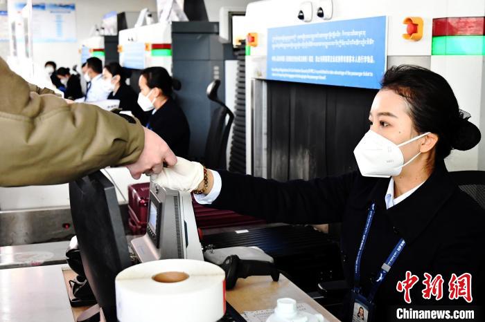 圖為機場工作人員為旅客辦理行李托運?！≈芎?攝