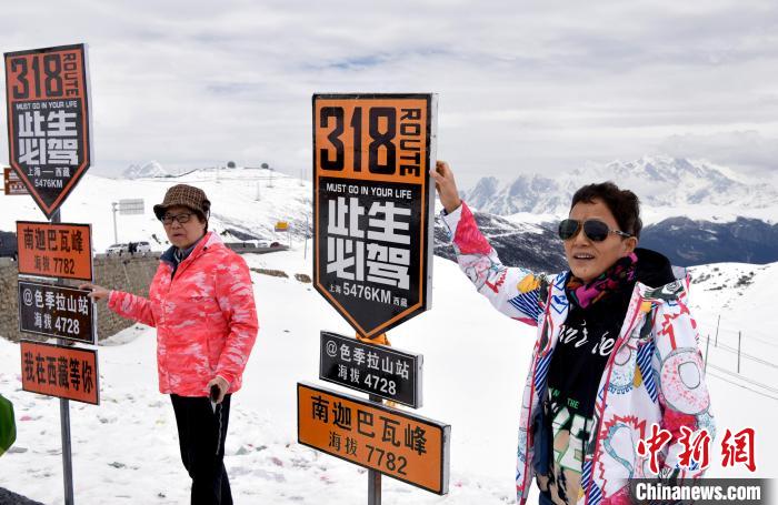 圖為5月14日，西藏林芝色季拉山觀景臺(tái)，游客與南迦巴瓦峰合影?！±盍?攝