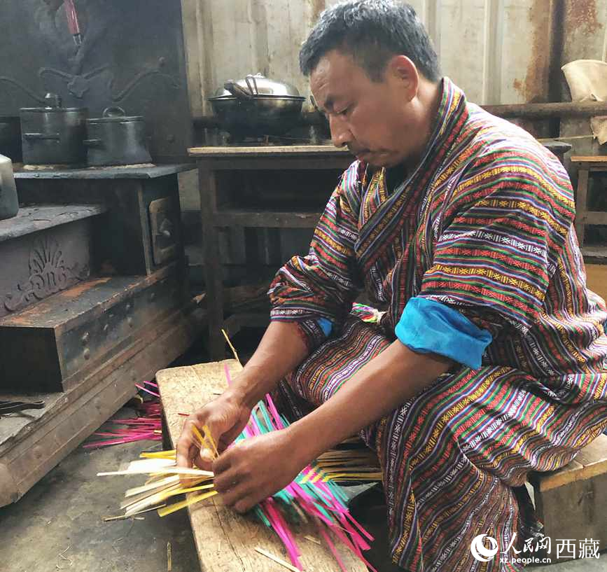 門巴族漢子愛明正在編織藤竹品。