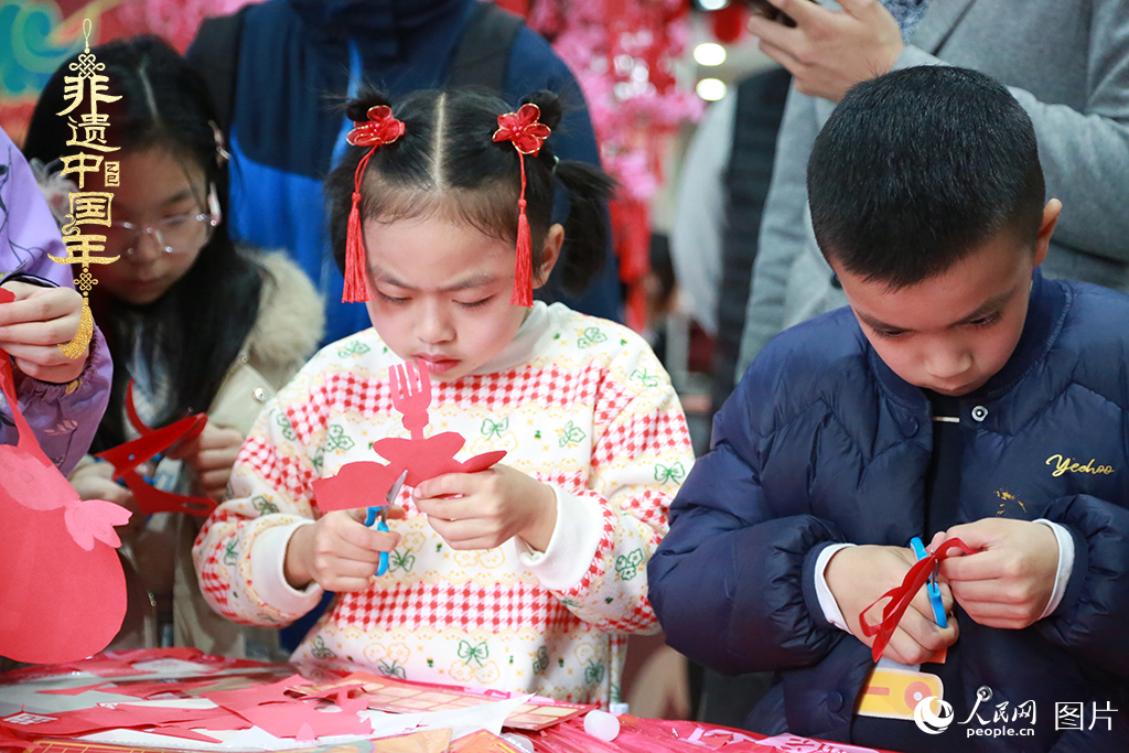 2025年1月23日，上海市青少年活動(dòng)中心迎新春游園會(huì)上，小朋友們正在學(xué)習(xí)剪窗花。人民網(wǎng)記者 龔莎攝
